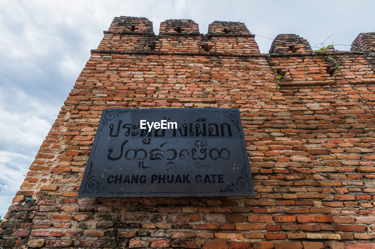 LOW ANGLE VIEW OF TEXT ON BRICK WALL