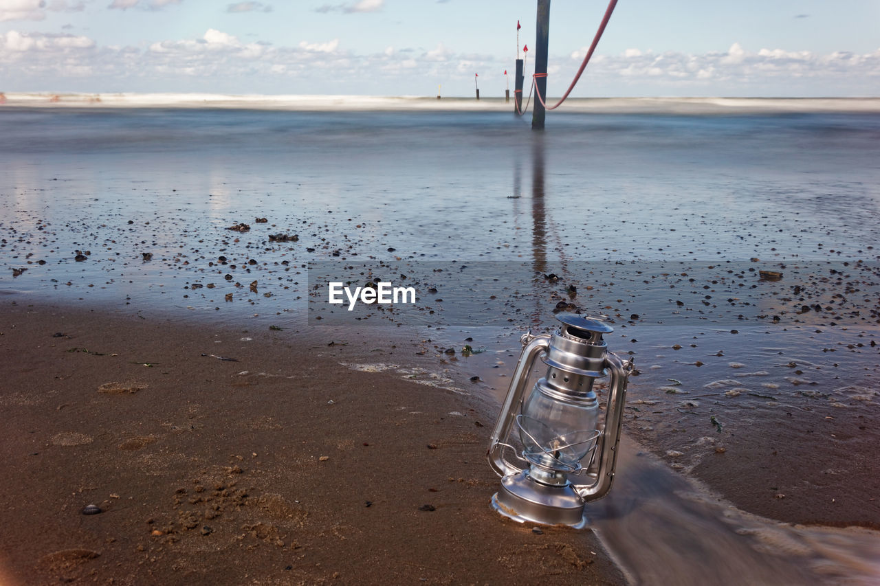 WET GLASS BOTTLE ON BEACH