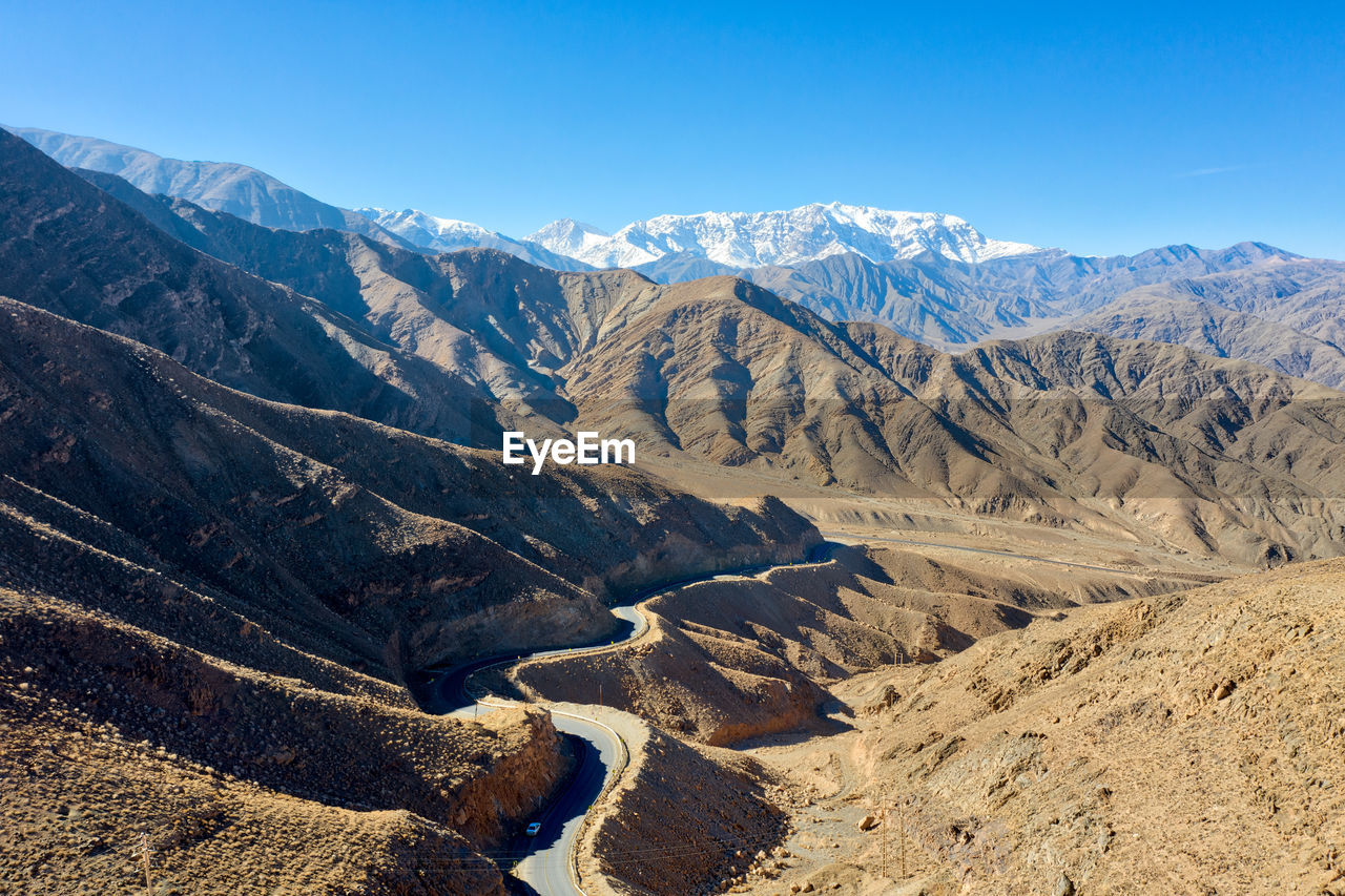 Scenic view of snowcapped mountains against clear blue sky