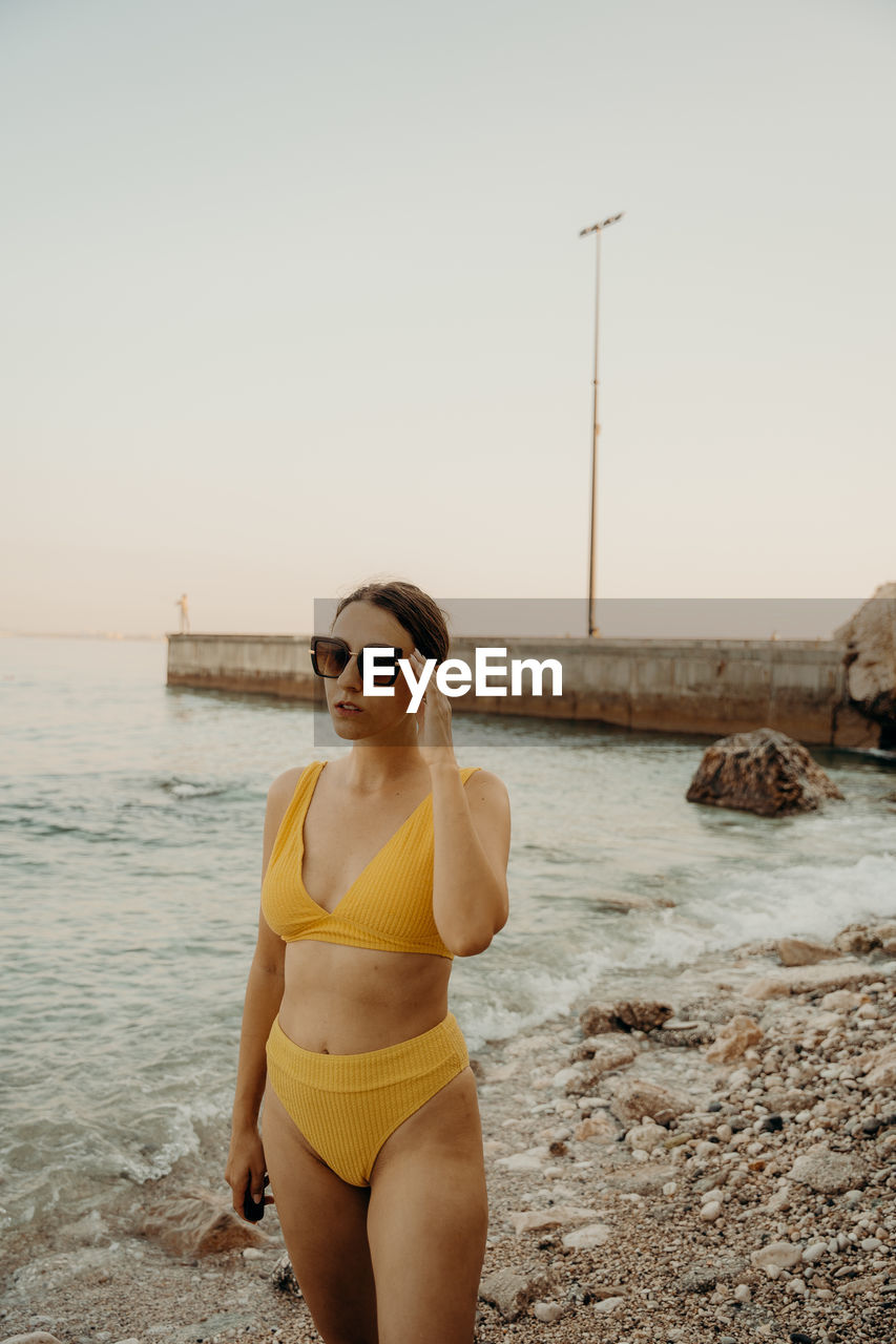 A girl on the beach with a yellow bikini