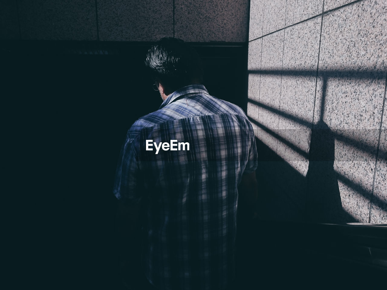 Rear view of man standing by wall