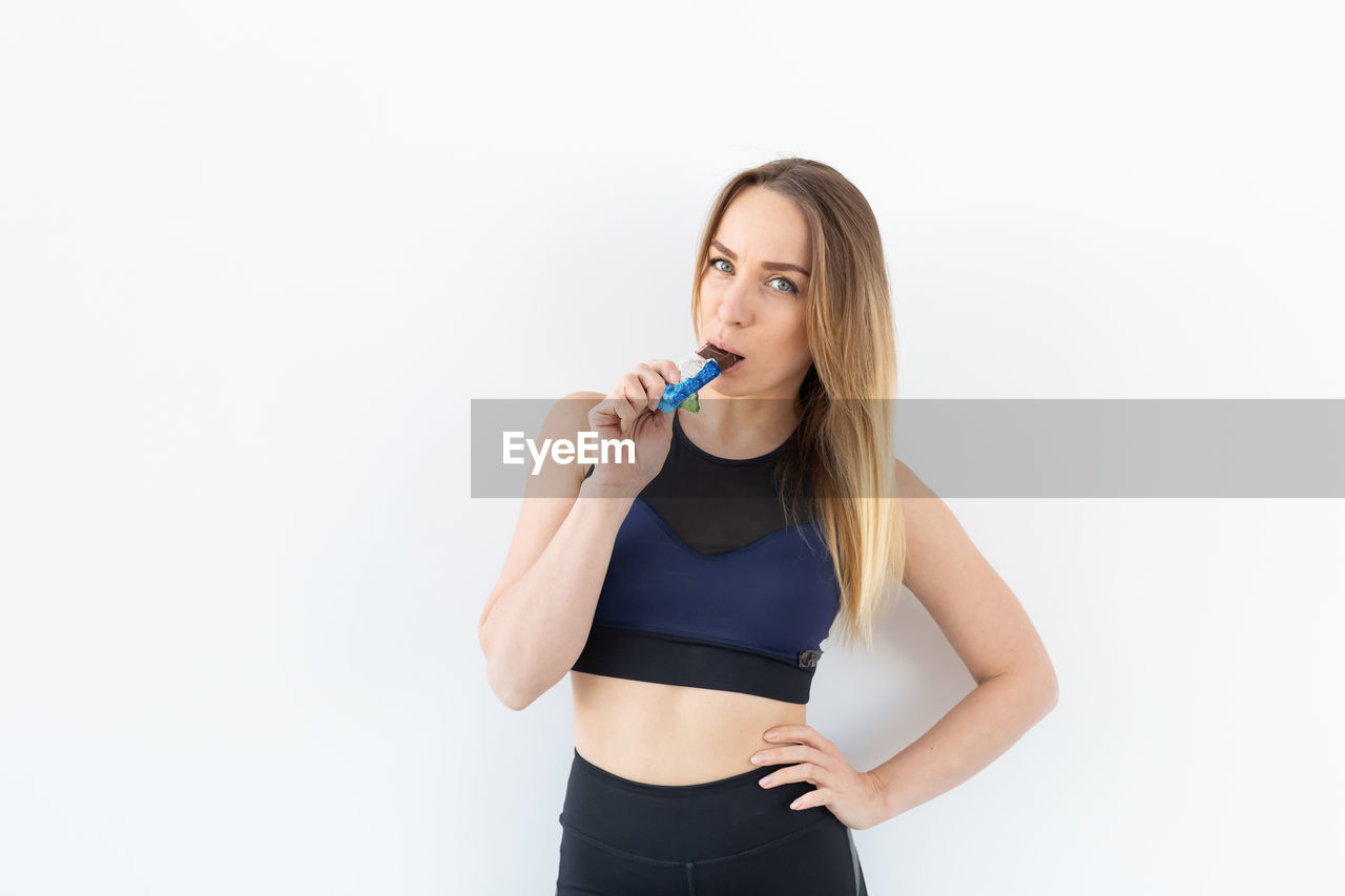 PORTRAIT OF A YOUNG WOMAN AGAINST WHITE BACKGROUND