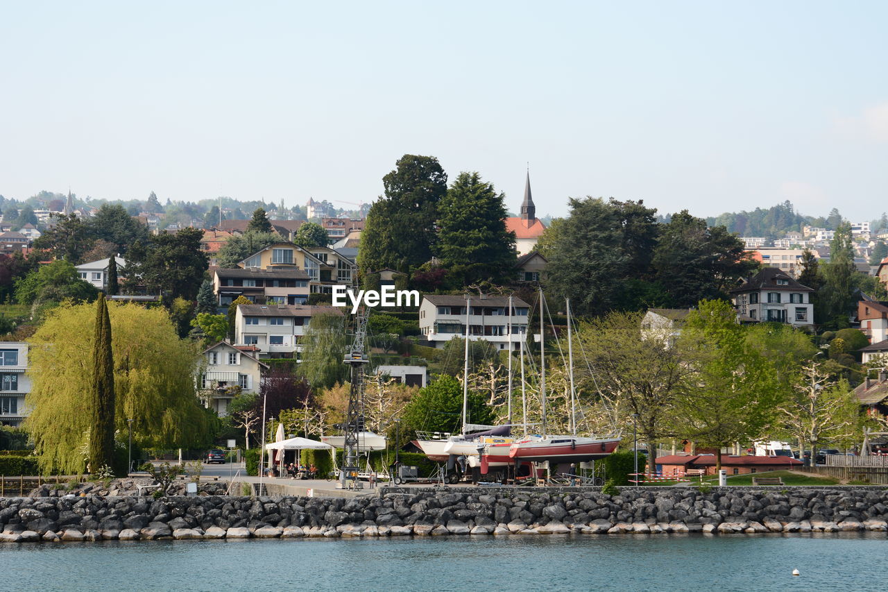 BUILDINGS BY RIVER AGAINST SKY