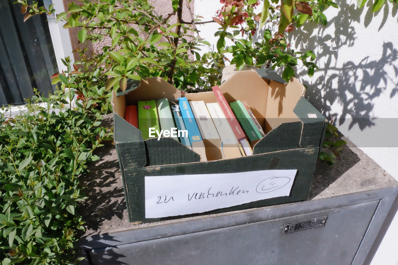 CLOSE-UP OF POTTED PLANT WITH TEXT ON BOOK