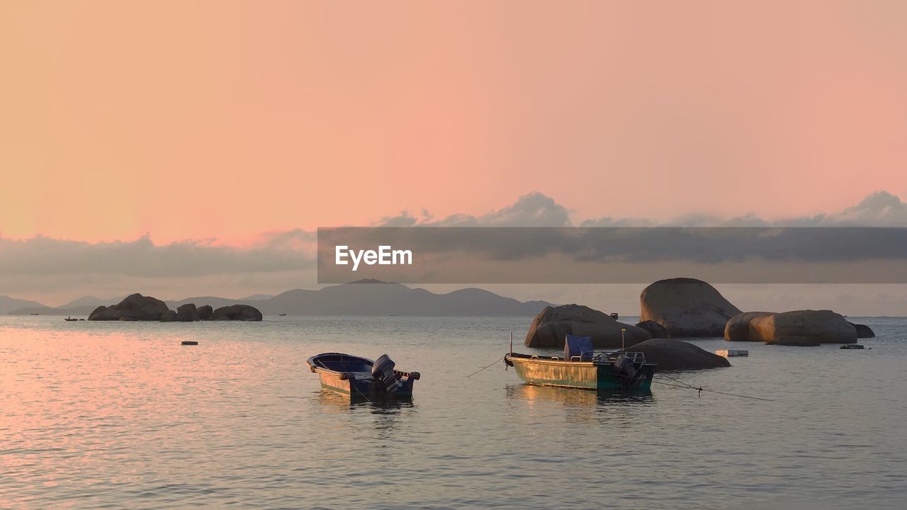 BOATS IN SEA AGAINST SKY DURING SUNSET