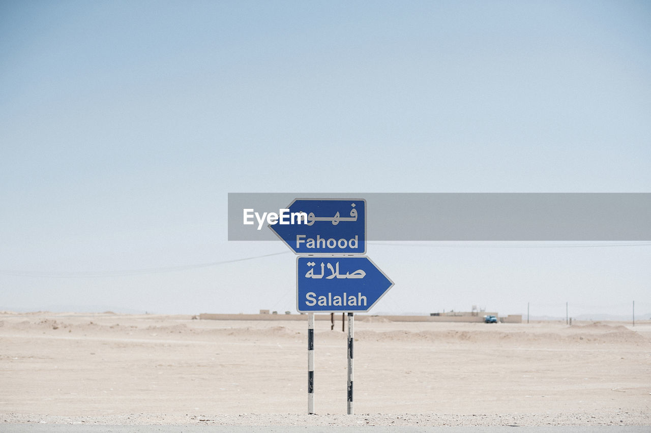 Signboards on desert against clear sky