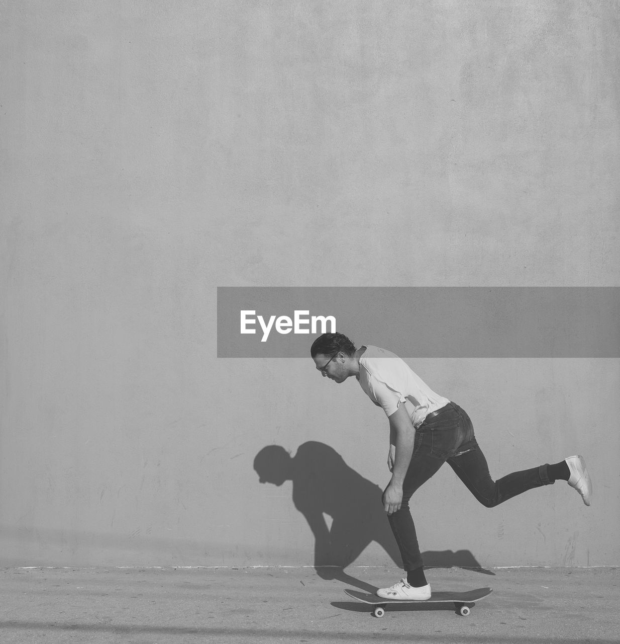 Man skateboarding against wall