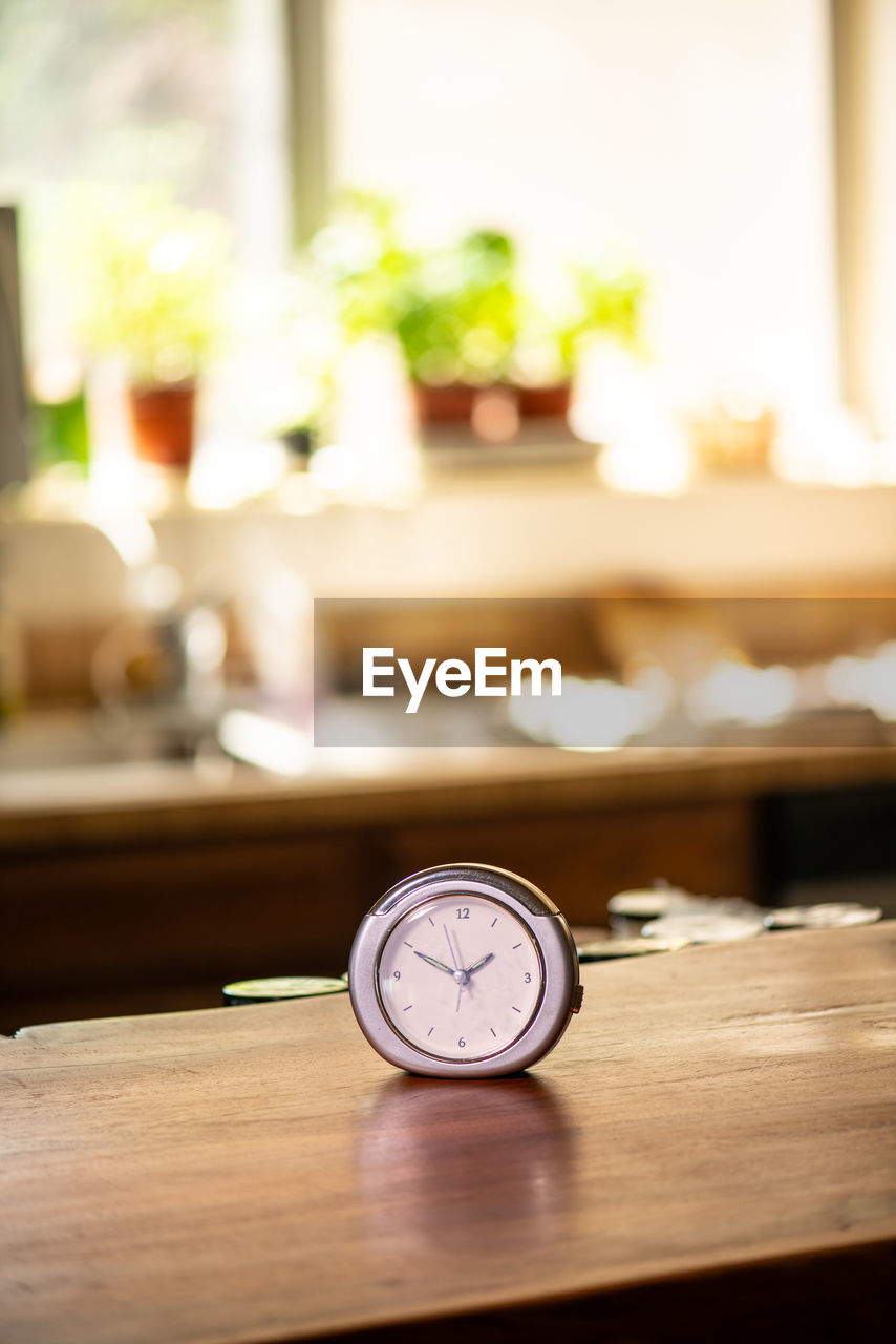 CLOSE-UP OF CLOCK ON TABLE AT HOME