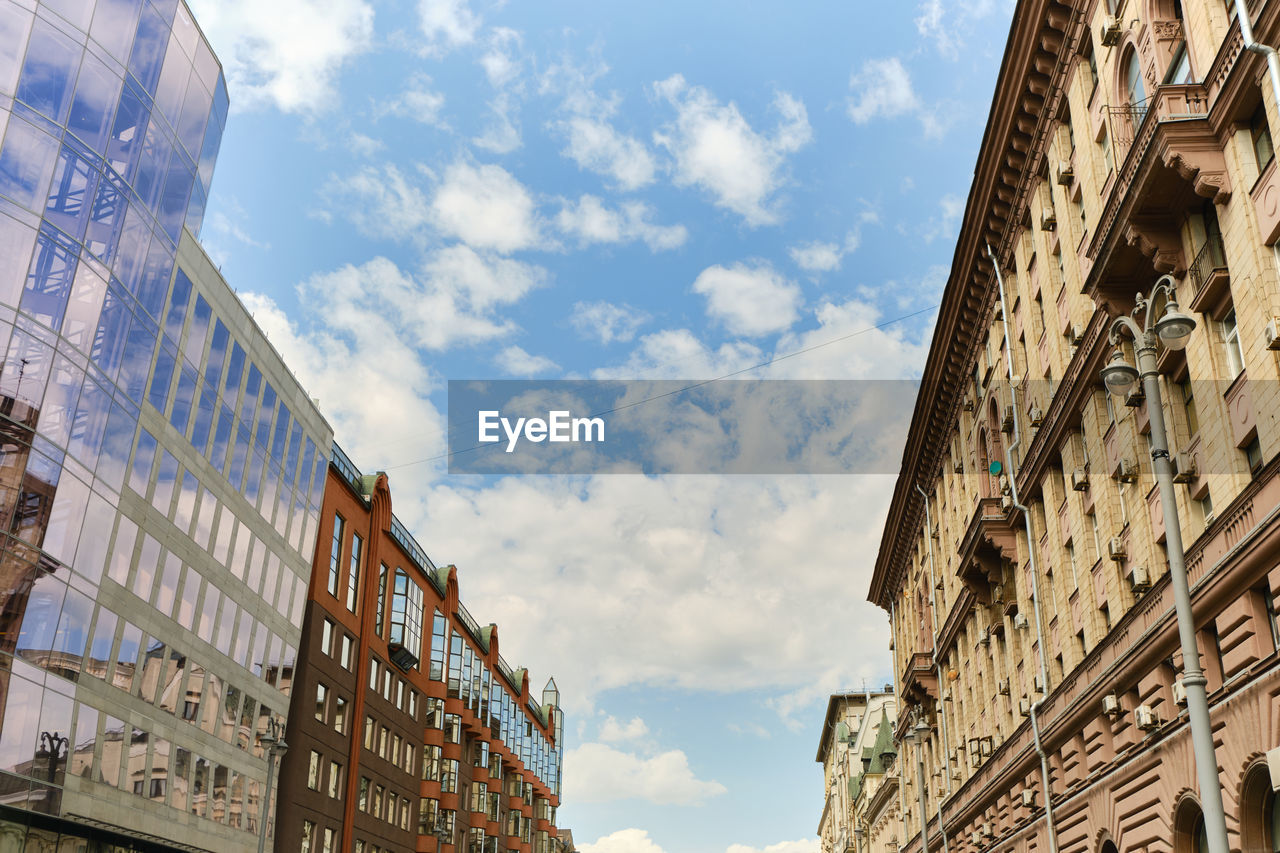 Low angle view of residential modern buildinds, windows and drainpipe. blue sky with clouds.