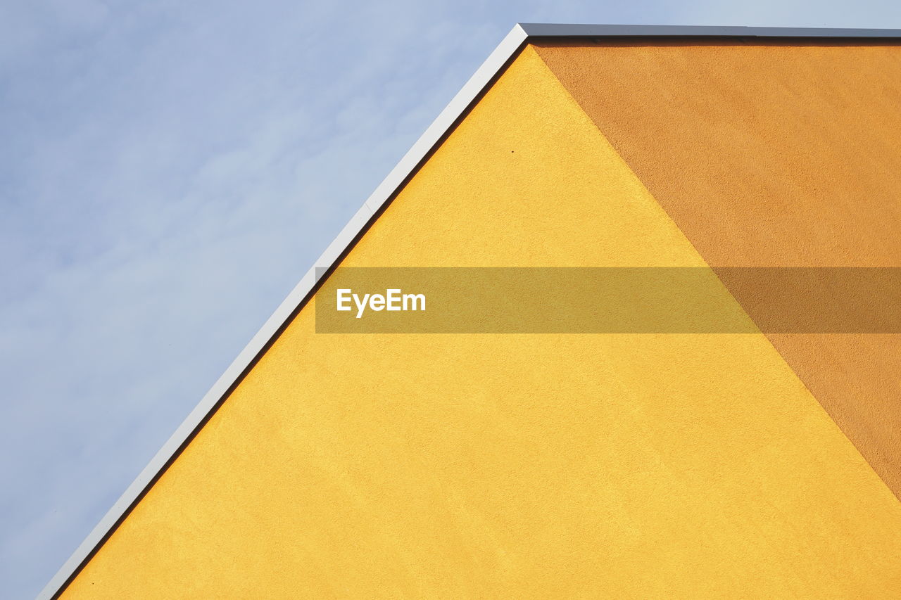 Low angle view of yellow building against sky