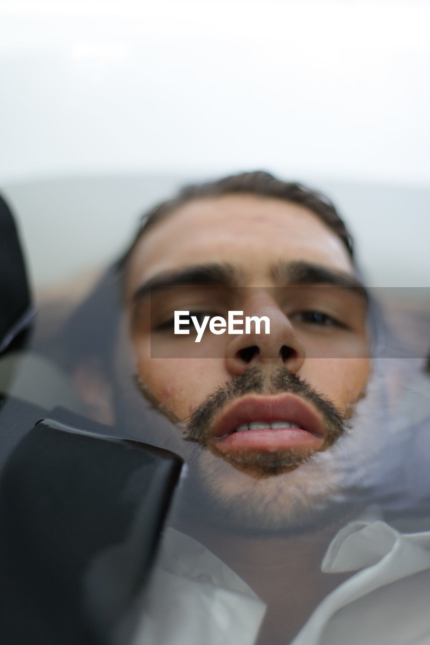 Close-up portrait of man in bathtub
