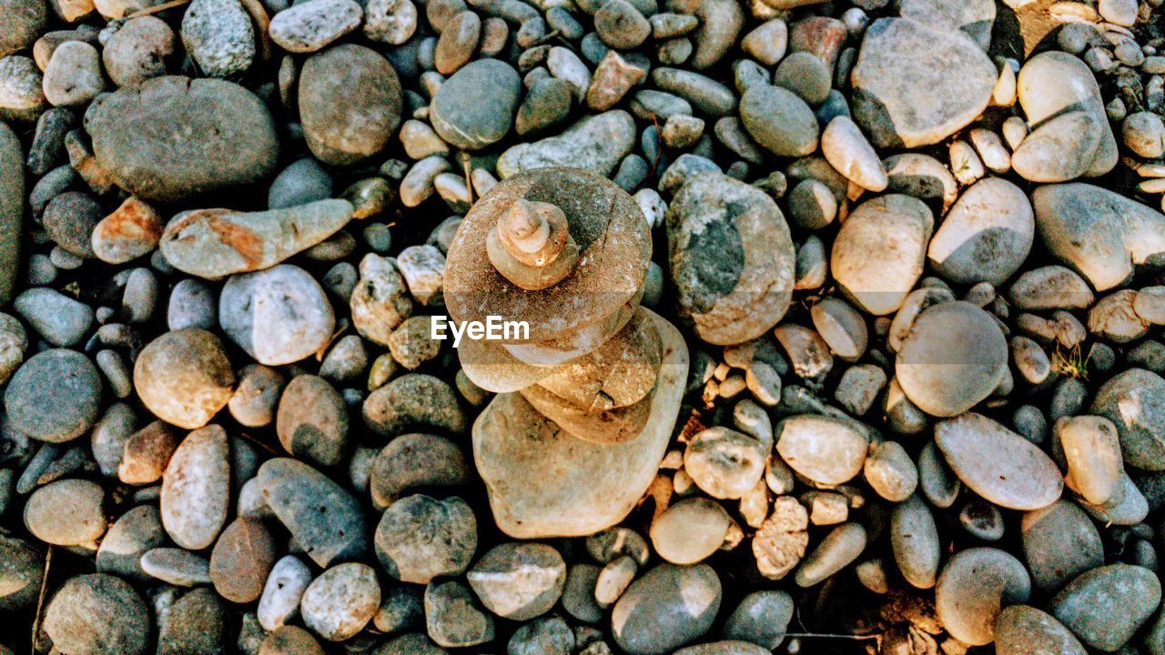 FULL FRAME SHOT OF PEBBLES ON ROCKS