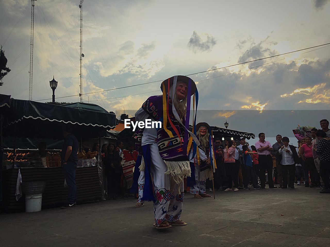 GROUP OF PEOPLE AT AMUSEMENT PARK DURING SUNSET