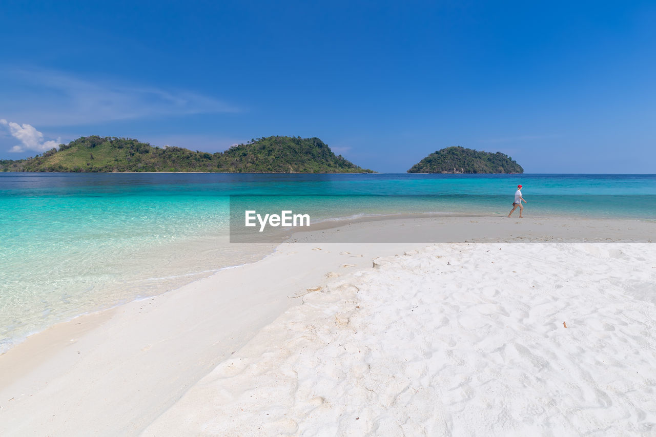 Scenic view of beach against blue sky