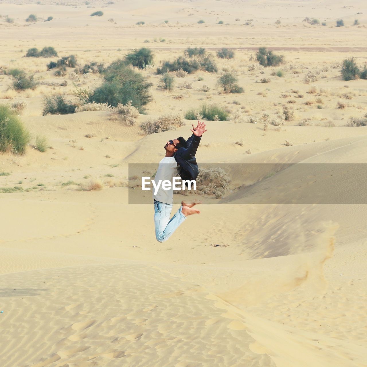 Full length of man jumping over sand at beach