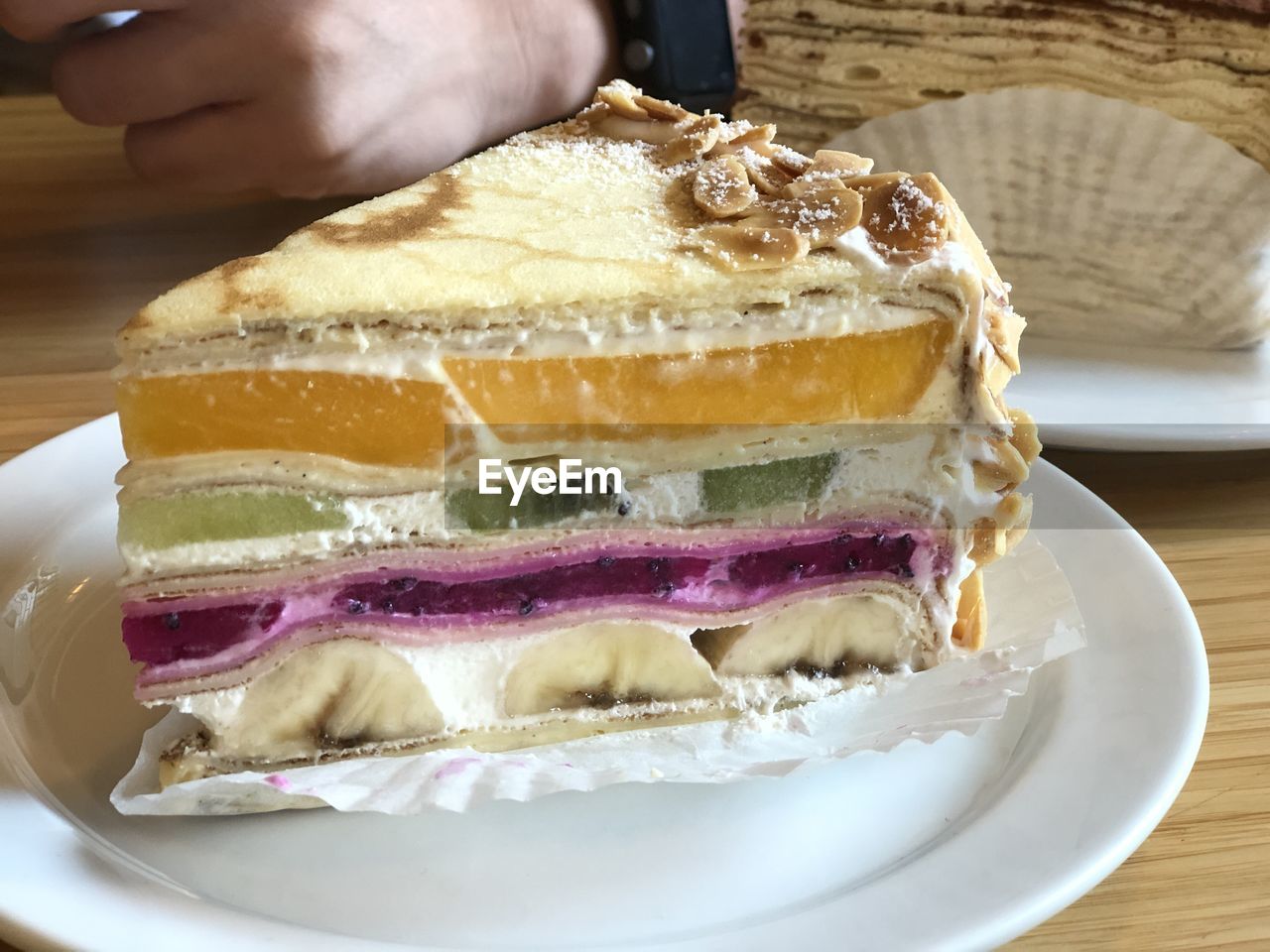 food and drink, food, fast food, dish, hand, breakfast, freshness, one person, bread, meal, indoors, close-up, ham and cheese sandwich, table, plate, sandwich, sweet food, produce, healthy eating, baked, cuisine, cake, lunch, muffuletta, dessert, wood, slice, sweet, adult, holding