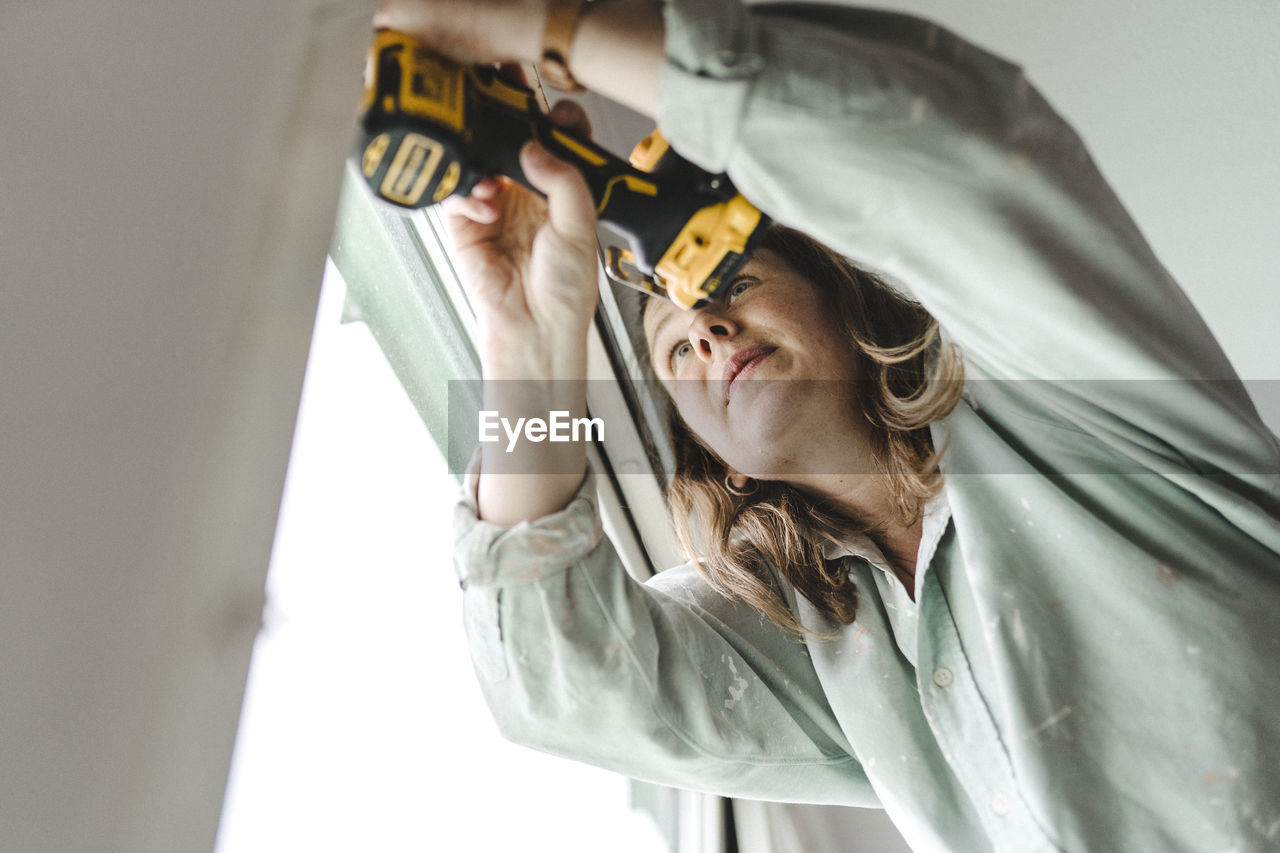 Woman using electric drill