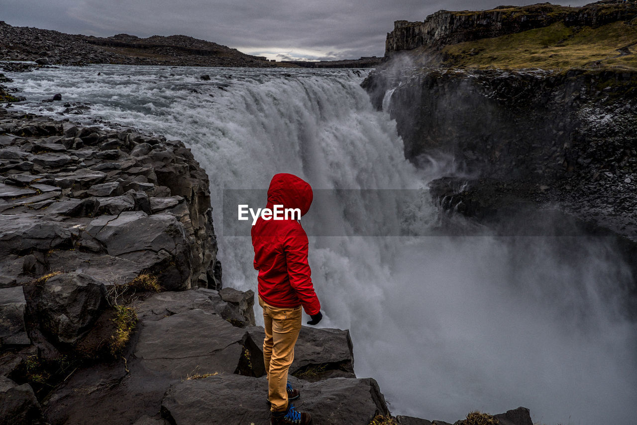 Rear view of man in waterfall