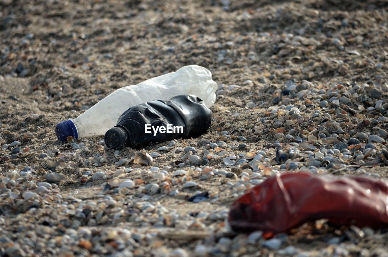 CLOSE-UP OF GARBAGE CAN ON DIRT