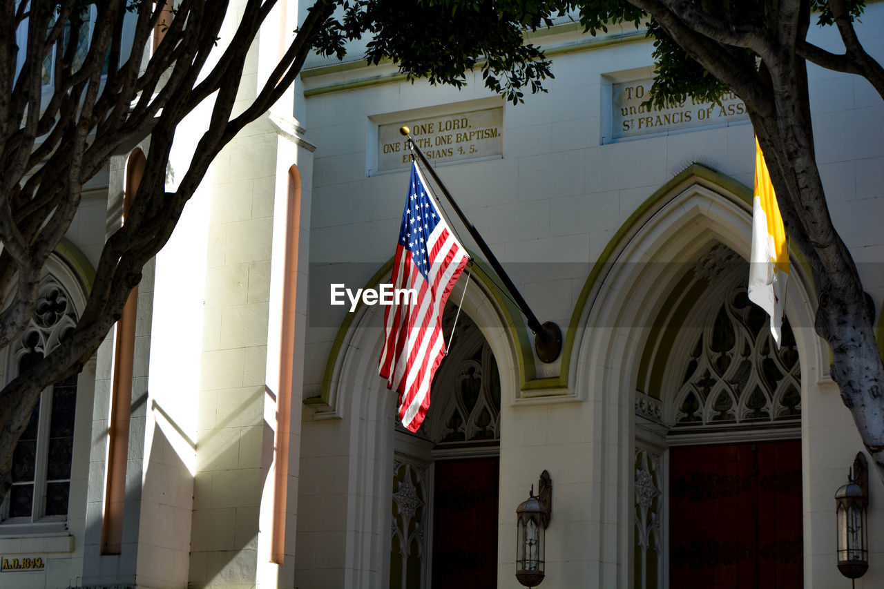 LOW ANGLE VIEW OF FLAG AGAINST BUILDINGS