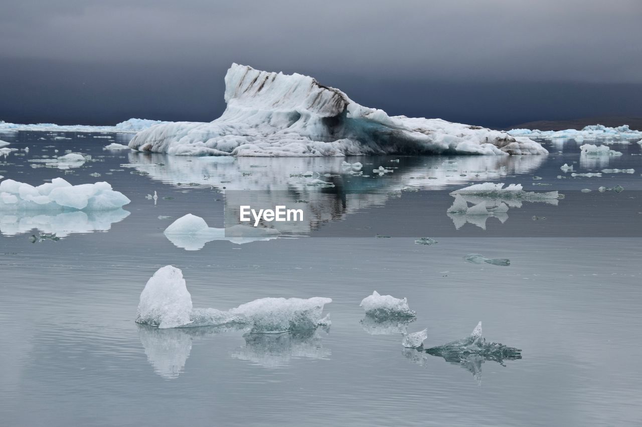 Scenic view of glaciers on lagoon against sky