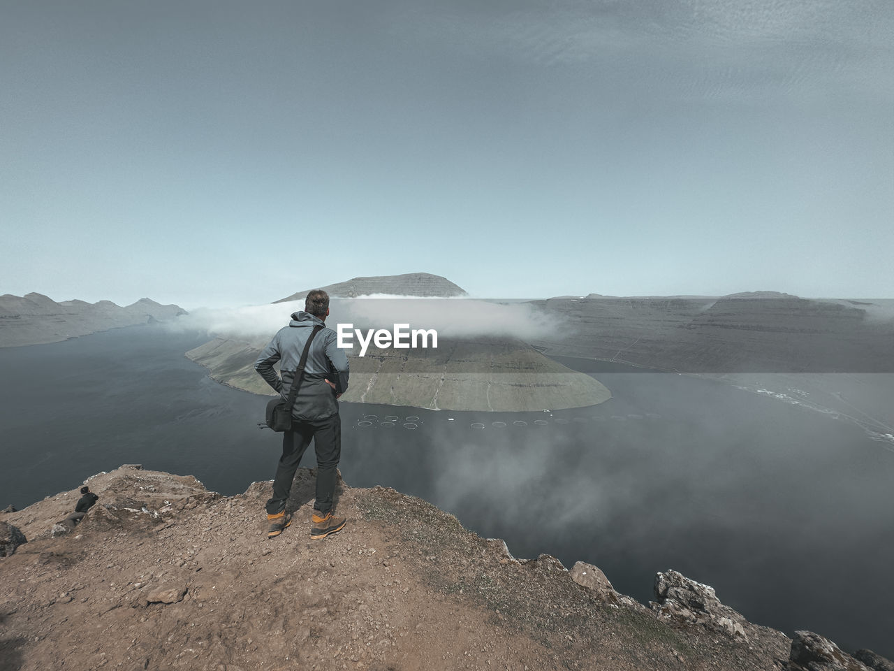 rear view of man walking on mountain against sky