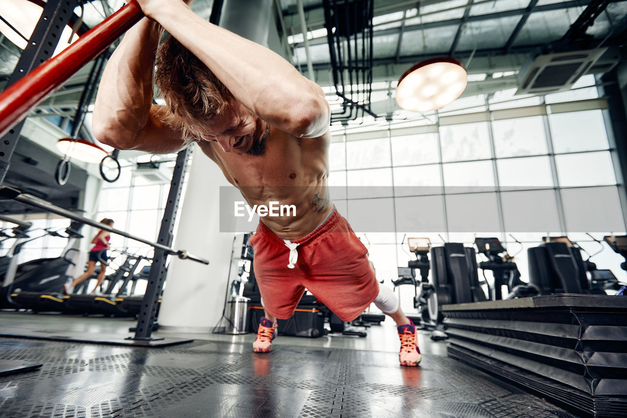 Muscular man exercising at gym