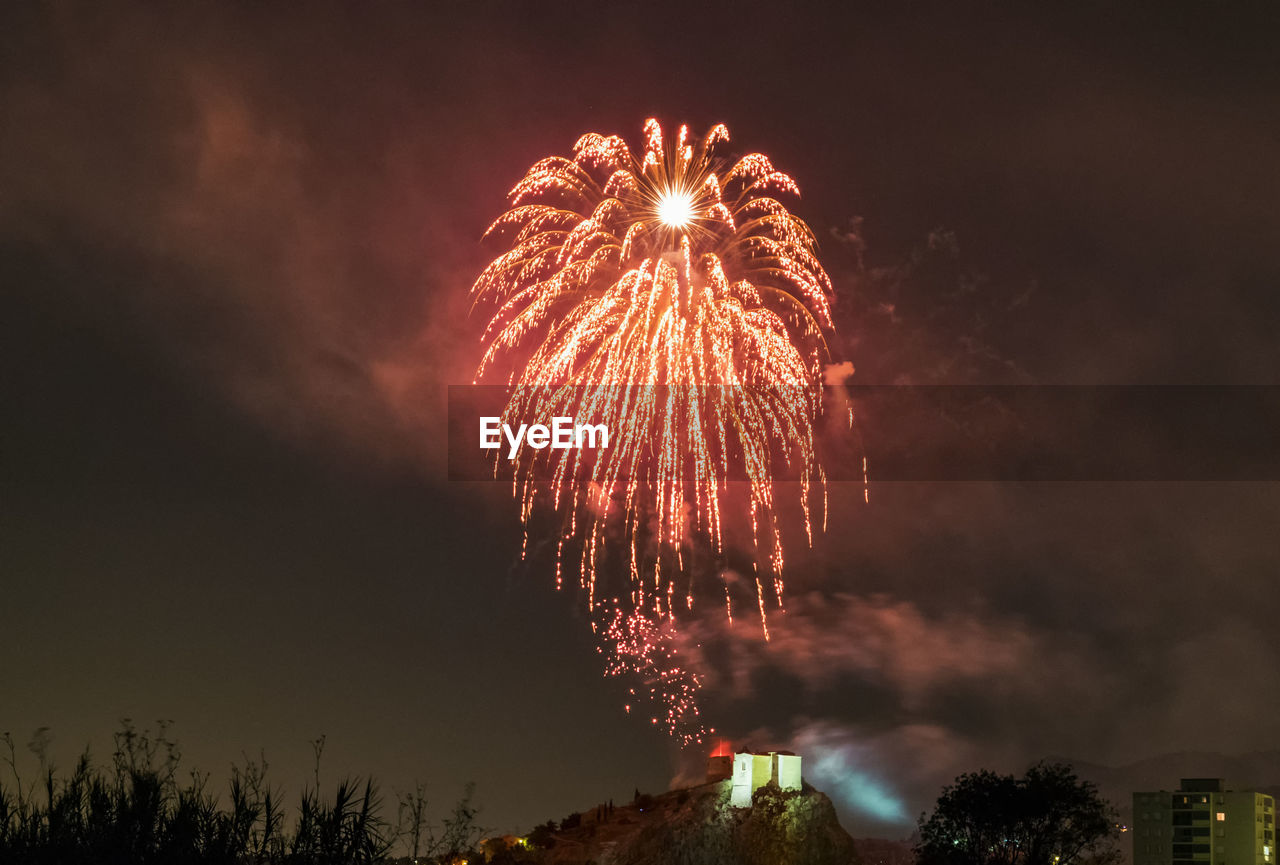 Low angle view of firework display at night