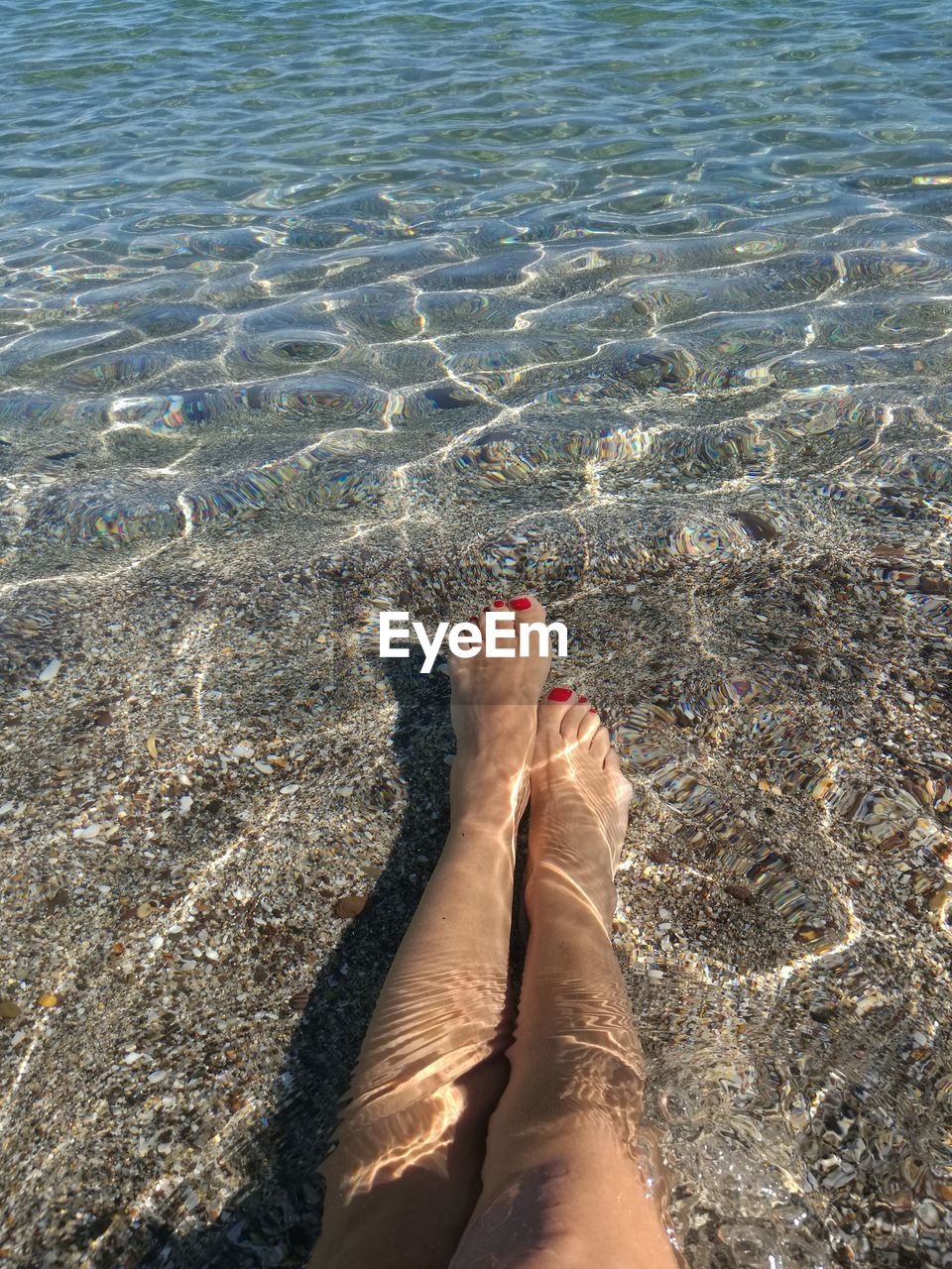 Low section of woman relaxing in river