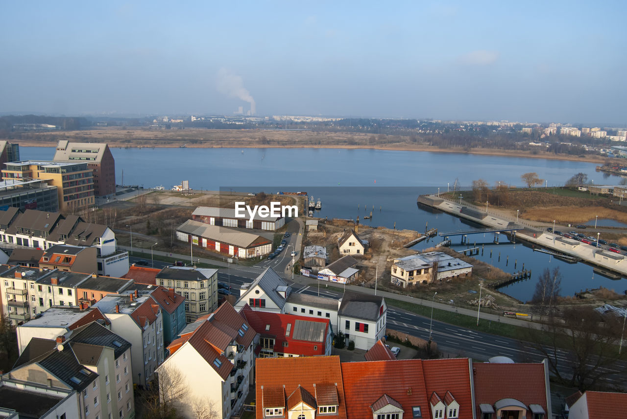 High angle view of buildings by sea against sky