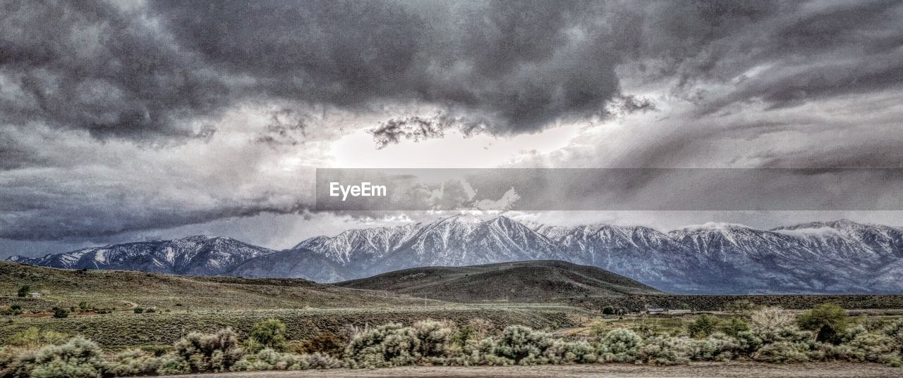 Scenic view of mountains against cloudy sky