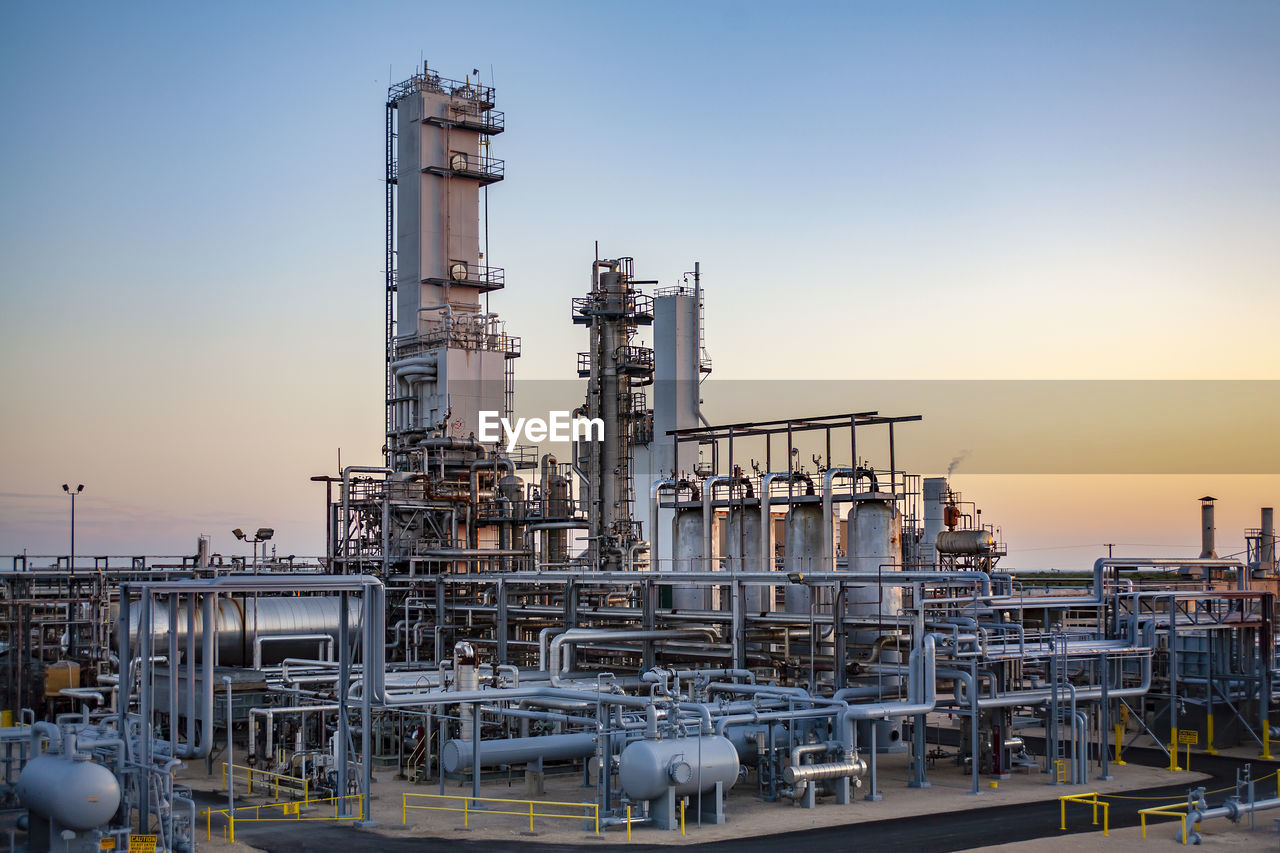 Industrial equipment against clear sky at oil refinery during sunset