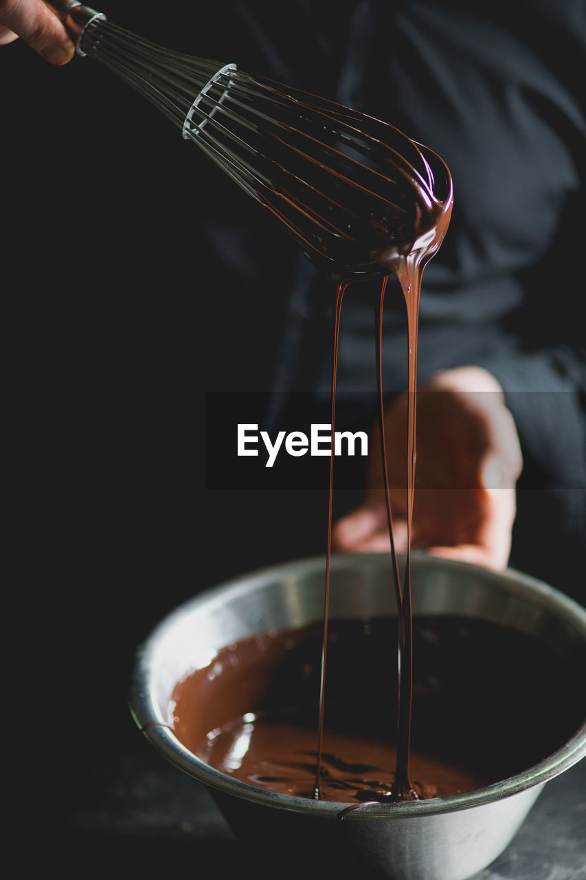 Close-up of wire whisk and melted chocolate