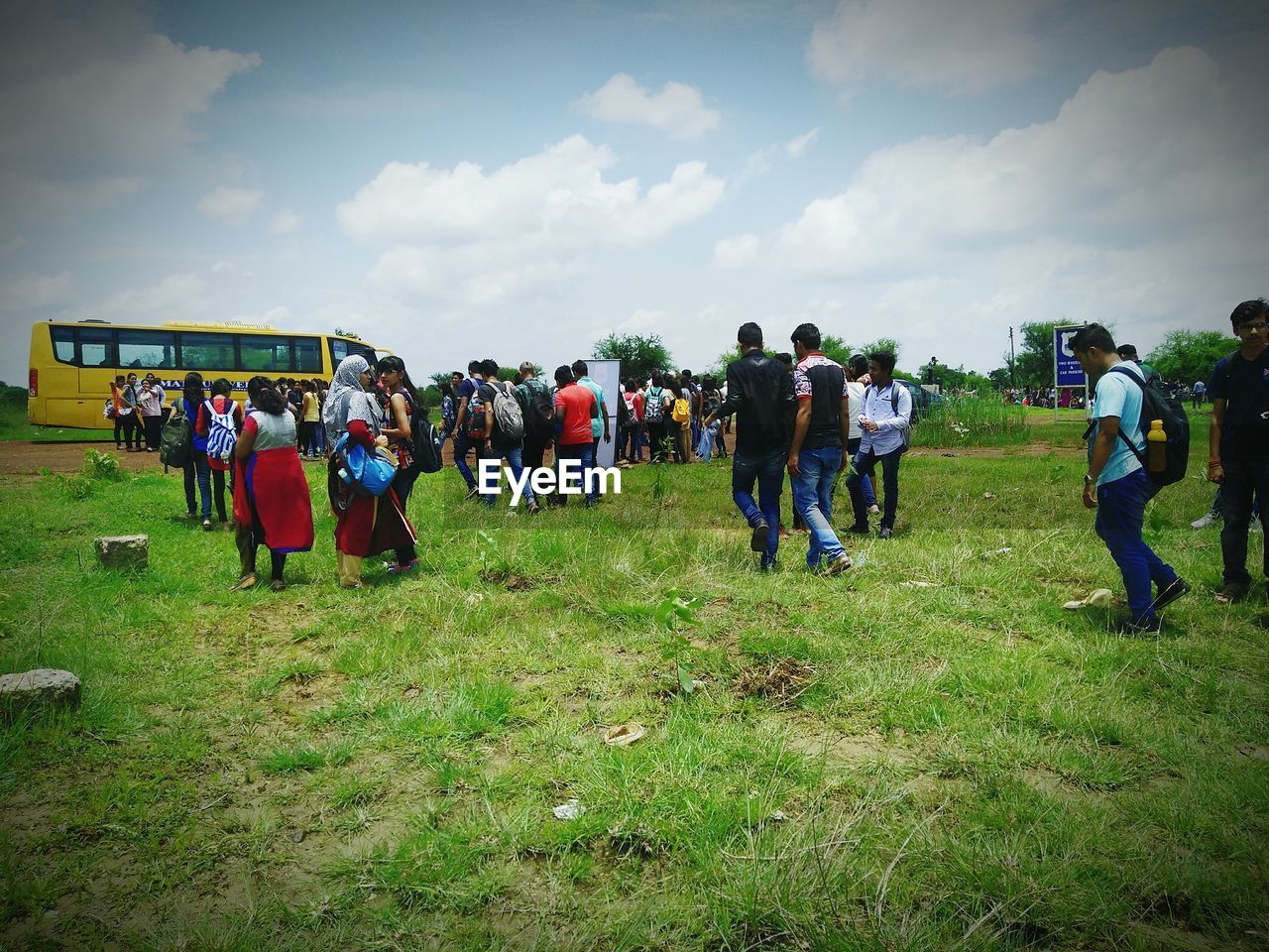 PEOPLE STANDING ON GRASSY FIELD