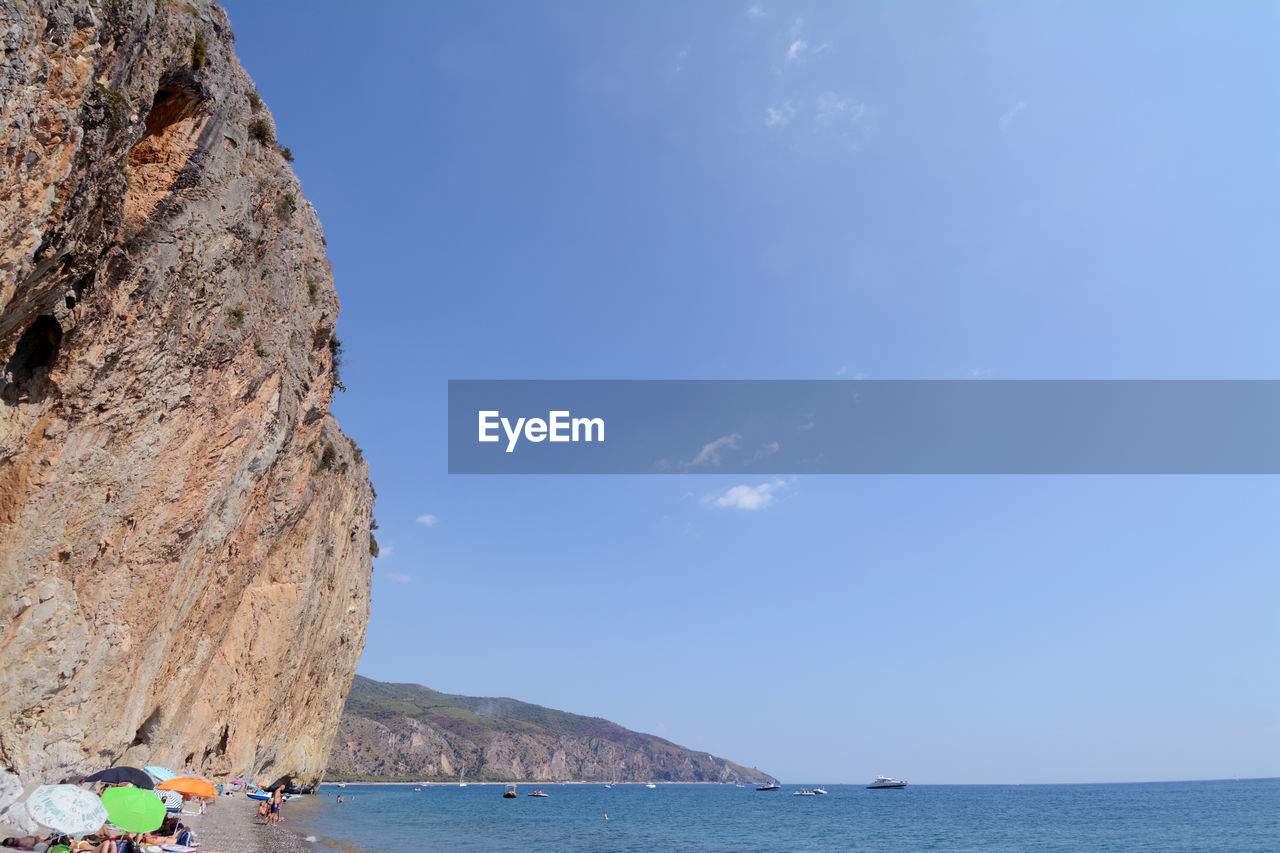 SCENIC VIEW OF SEA BY MOUNTAIN AGAINST SKY