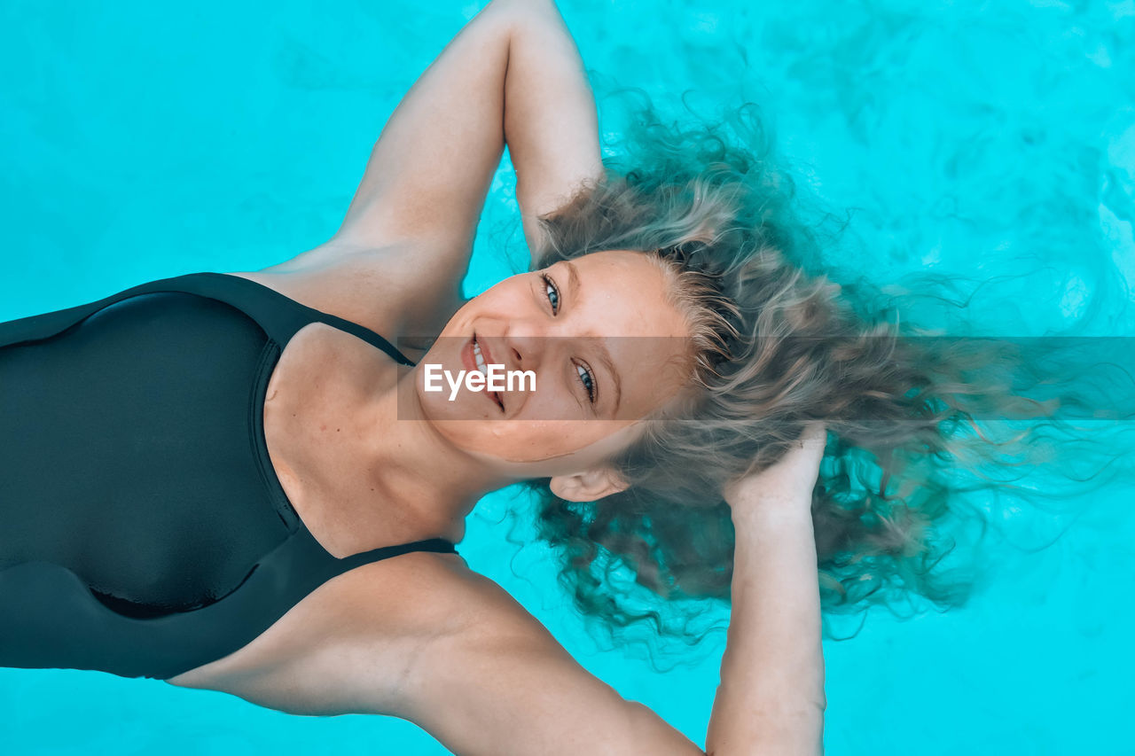 High angle portrait of young woman in swimming pool