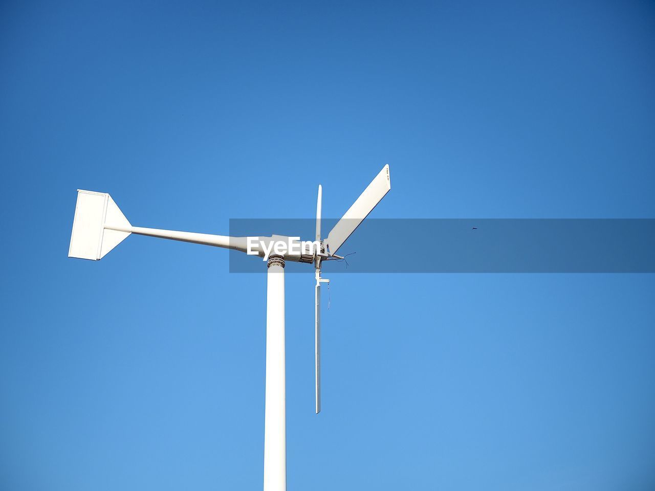 LOW ANGLE VIEW OF WIND TURBINE AGAINST BLUE SKY