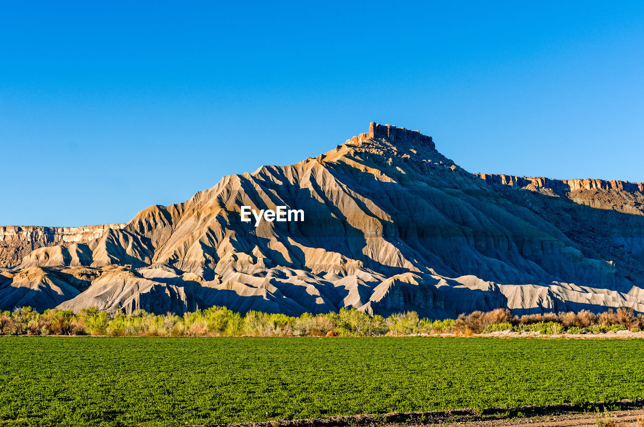 Scenic view of mountains against clear blue sky