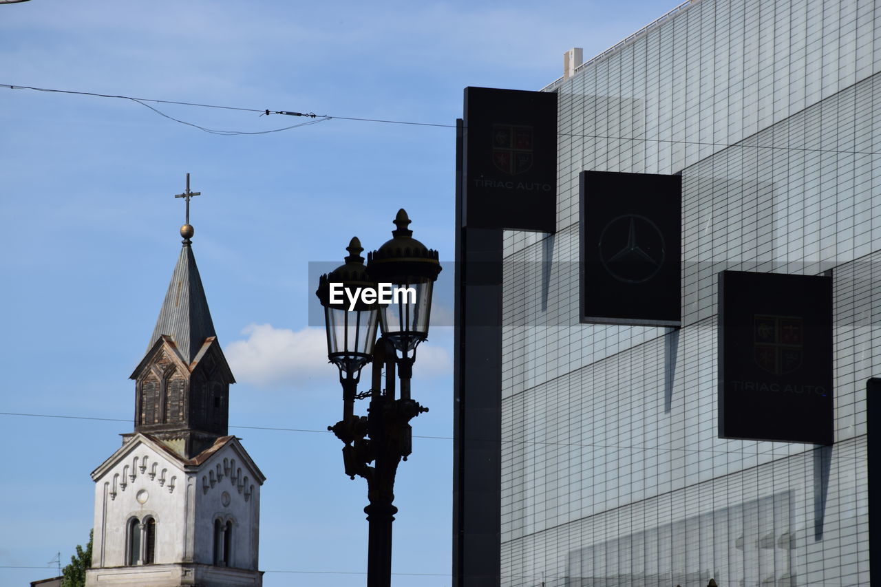 Low angle view of church and lamp posts by building against sky in city