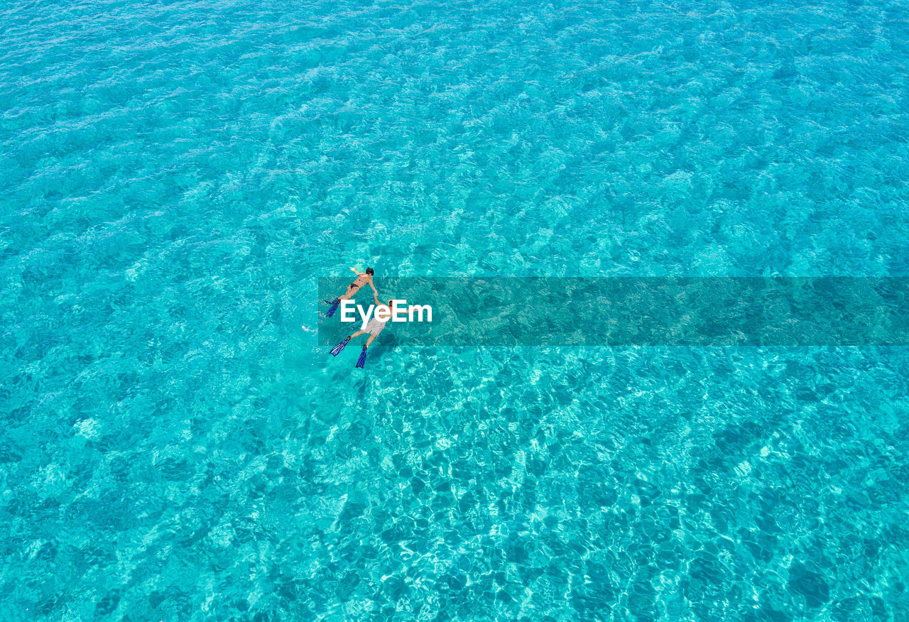 High angle view of couple swimming in sea