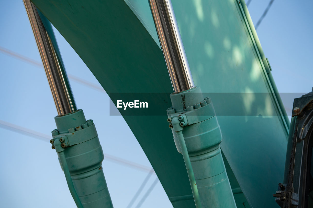 green, mast, industry, sky, vehicle, power generation, nature, low angle view, no people, transportation, day, architecture, outdoors, blue, fossil fuel, built structure, technology