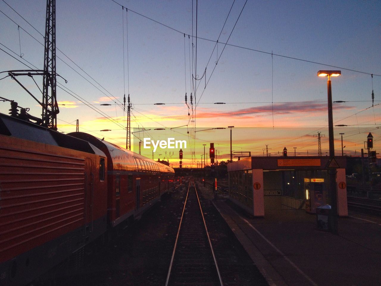 Train on railroad tracks during sunset
