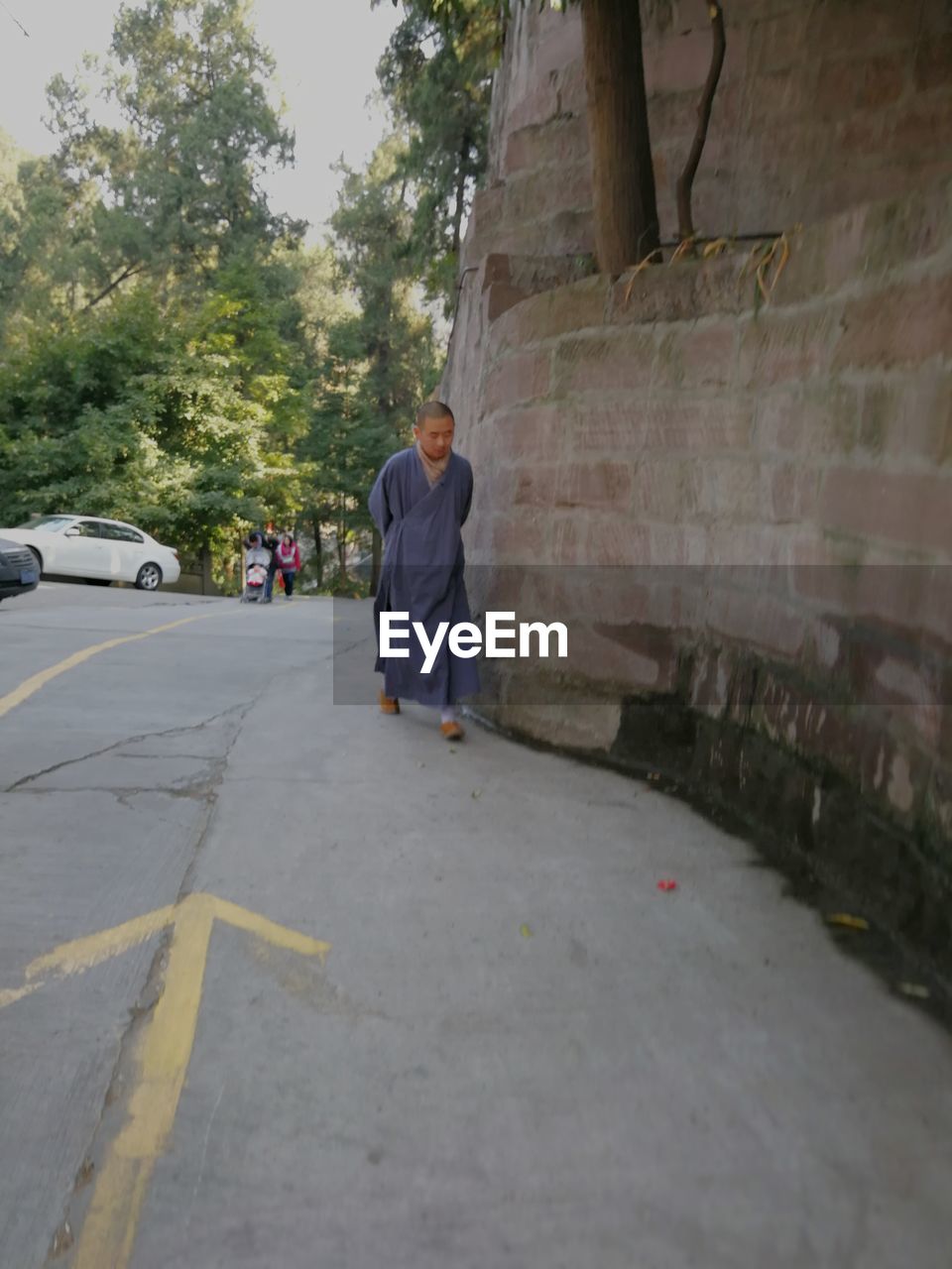 REAR VIEW OF MAN WALKING ON STREET