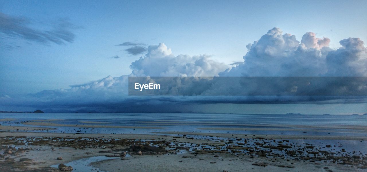 Scenic view of beach and sea against cloudy sky