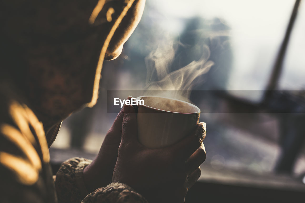 Midsection of person holding coffee cup