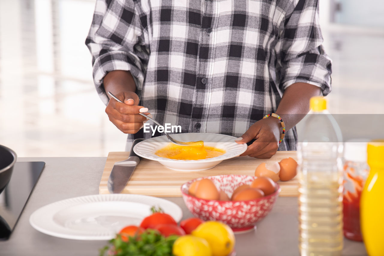 MIDSECTION OF MAN HAVING FOOD IN BOWL