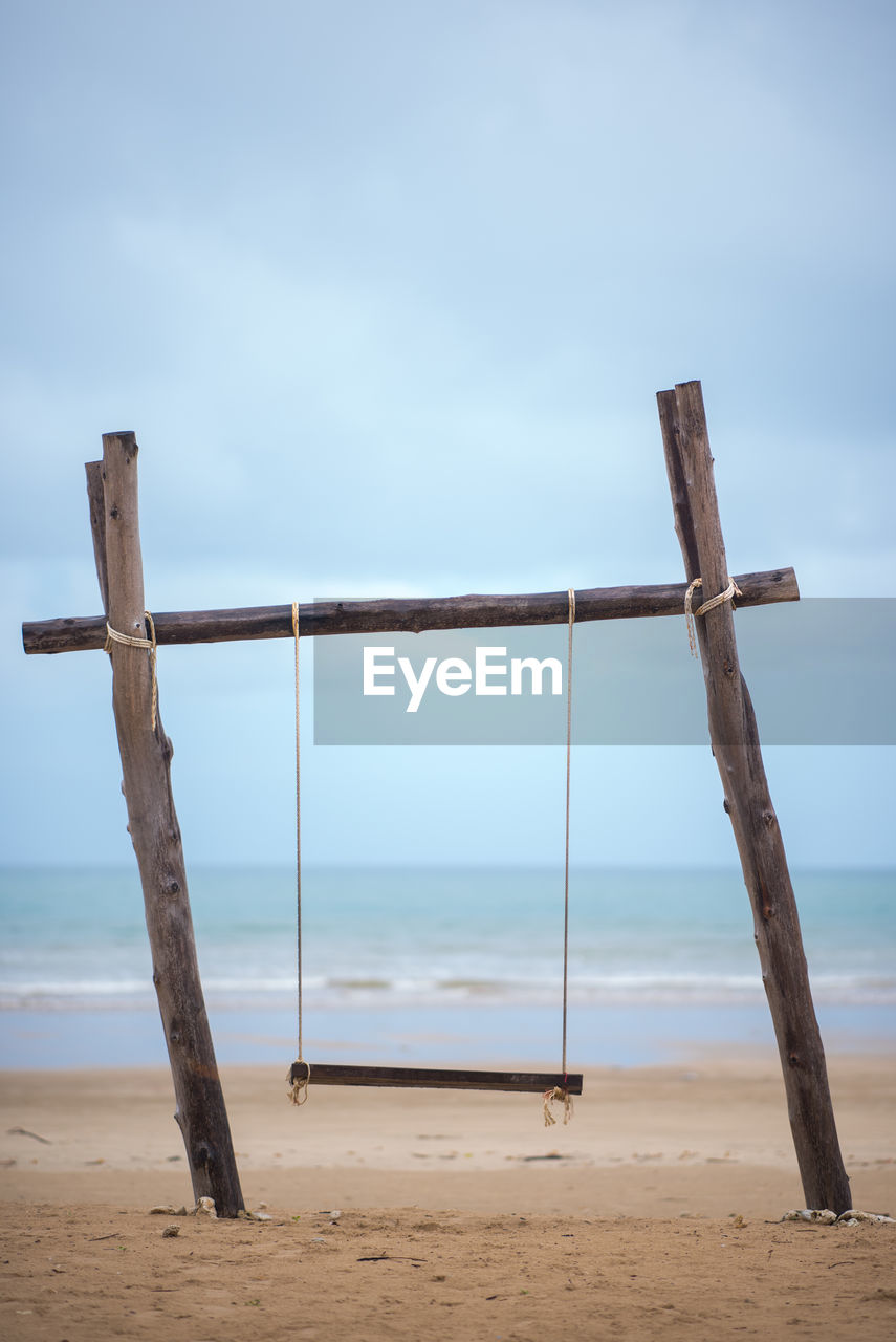 WOODEN POSTS ON BEACH