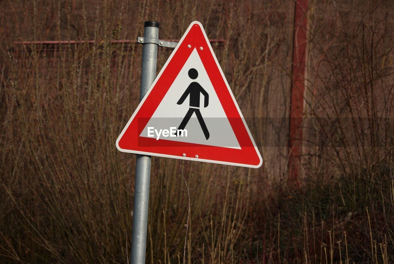 sign, warning sign, communication, triangle shape, traffic sign, road, signage, road sign, shape, representation, no people, guidance, red, human representation, street sign, number, nature, warning symbol, triangle, geometric shape, day, plant, information sign, outdoors