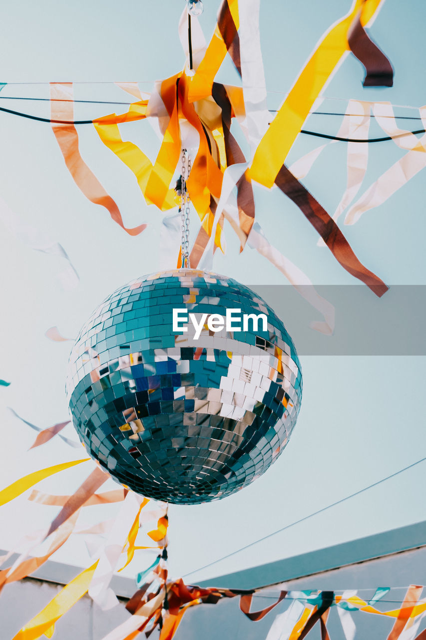 Disco ball on a background of blue sky. low angle view of decoration hanging on ceiling