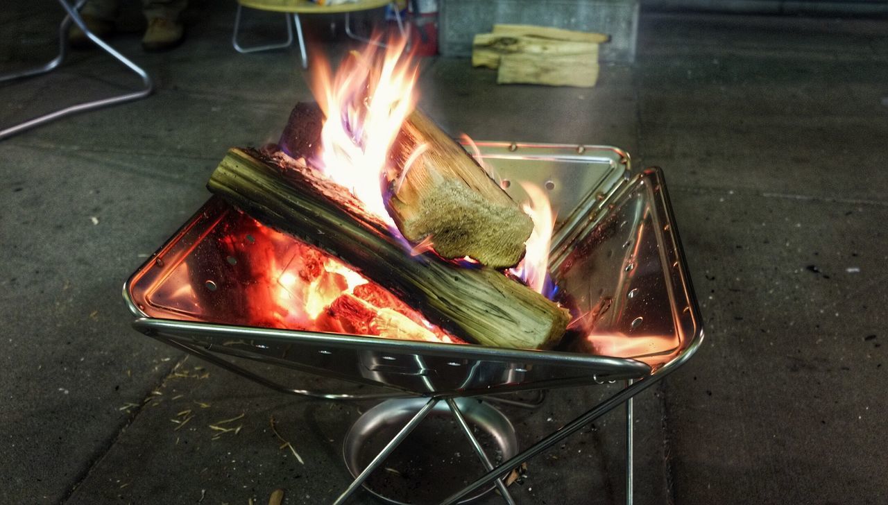 Close-up of wood burning on sidewalk cafe